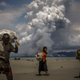 Smoke is seen on the Myanmar border as Rohingya refugees walk on the shore after crossing the Bangladesh-Myanmar border by boat through the Bay of Bengal, in Shah Porir Dwip, Bangladesh, in September 2017.